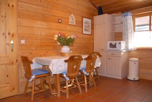 La cuisine est équipée d'une table, de chaises et d'un réfrigérateur. dans l'établissement Waldhofalm Angerer, à Berchtesgaden