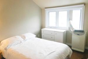um quarto com uma cama branca e uma janela em Les Condos de la Montagne 2 em Beaupré