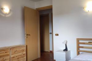 een slaapkamer met een bed, een dressoir en een lamp bij Court of Artist Friuli in Sedegliano