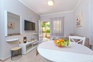 a white living room with a table and a dining room at Apartments with a parking space Mali Losinj (Losinj) - 15201 in Mali Lošinj