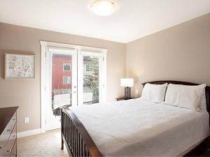 a bedroom with a large bed and a window at Breakaway Beach Villa near Lake in Penticton