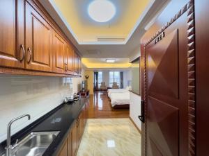 a kitchen with a sink and a bed in a room at Guangzhou Zhicheng Leader Tour International Apartment in Guangzhou