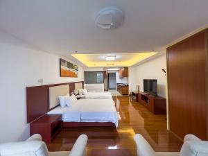 a hotel room with two beds and a flat screen tv at Guangzhou Zhicheng Leader Tour International Apartment in Guangzhou