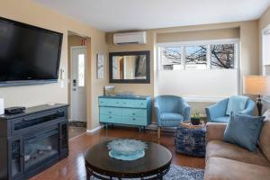 a living room with a couch and a tv at Breezy Beach Villa near the Lake in Penticton