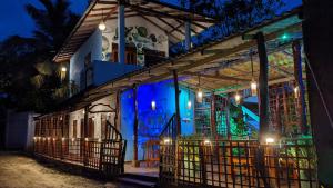 a house with a lit up facade at night at Canoe Beach House & Spa in Tangalle