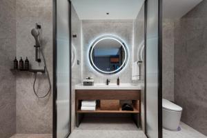 a bathroom with a sink and a mirror at UrCove by Hyatt Hangzhou Xiaoshan International Airport in Hangzhou