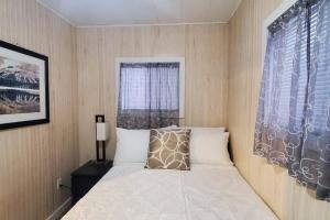 Habitación pequeña con cama y ventana en Relaxing Riverside Getaway with a Cozy Fireplace, en Bancroft