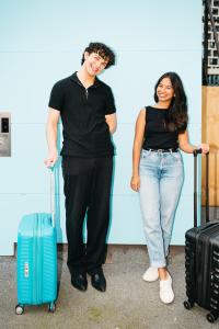 a man and a woman standing with their luggage at The Village Melbourne in Melbourne