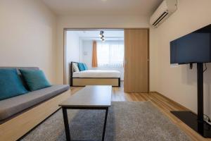 a living room with a couch and a tv at Wellsquareism Otsuka in Tokyo