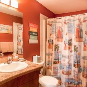 a bathroom with a sink and a toilet and a shower curtain at Orchard & Vines Villa Penticton in Penticton