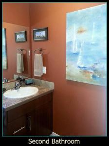 a bathroom with a sink and a painting on the wall at Orchard & Vines Villa Penticton in Penticton