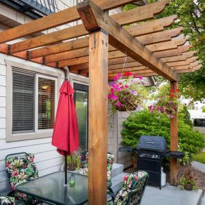 a patio with a table and a wooden pergola at Orchard & Vines Villa Penticton in Penticton