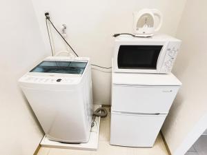 宜野湾市にあるBiBi Hotel FUTENMAの電子レンジと洗濯機が隣り合わせになっています。
