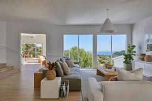 Una sala de estar con un sofá y algunas ventanas. en The Cape Retreat, en Cape Schanck