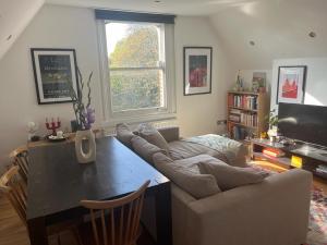 ロンドンにある2 bedroom top floor flat, West Dulwich FREE STREET PARKINGのリビングルーム(ソファ、テーブル付)