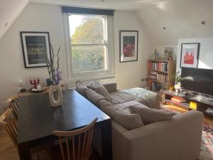 a living room with a couch and a table at 2 bedroom top floor flat, West Dulwich FREE STREET PARKING in London