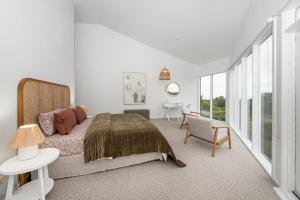 een slaapkamer met een bed, een tafel en een bureau bij The Cape Retreat in Cape Schanck
