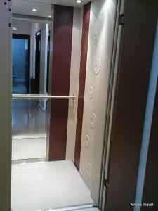 un armario vacío con una puerta de cristal y un espejo en Marie Claire Studios, en Olympiakí Aktí