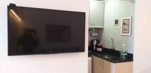 a flat screen tv hanging on a wall in a kitchen at Prime Flat Terê in Teresópolis