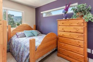 a bedroom with a wooden bed and a dresser at Peaches & Wine Villa Penticton in Penticton