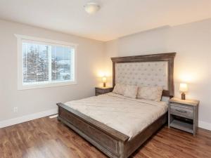 a bedroom with a large bed with two night stands at Vineyard Sunrise Villa near Lake in Penticton