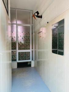 y baño con ducha a ras de suelo y ventana. en Trầm Homestay, en Thôn An Hòa
