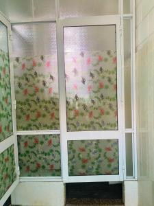 a pair of glass doors with flowers on them at Trầm Homestay in Thôn An Hòa