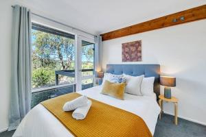 ein Schlafzimmer mit einem großen Bett und einem großen Fenster in der Unterkunft Parvatii-Perfect Adelaide Escape-15 mins to City & Wineries in Glenunga
