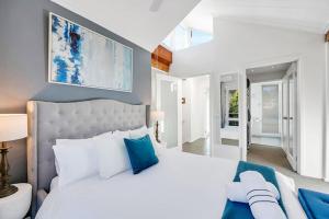a bedroom with a white bed and blue pillows at Parvatii-Perfect Adelaide Escape-15 mins to City & Wineries in Glenunga