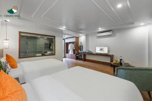 um quarto branco com uma cama, um sofá e uma mesa em Charm Hill Sapa Hotel em Sapa