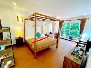 1 dormitorio con cama con dosel en una habitación en Sabbay Kep, en Kep