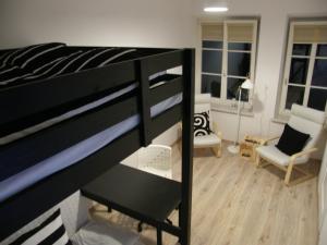 a bedroom with a bunk bed and a living room at Apartament Jagielloński in Krakow