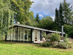 una casa con grandes puertas de cristal en un patio en Holiday home Hornbæk II, en Hornbæk