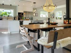 a kitchen and dining room with a wooden table and chairs at Holiday home RÅÅ in Råå 