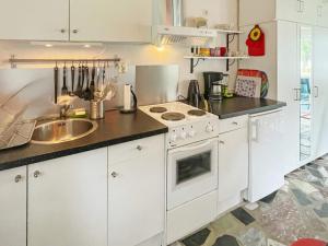 a kitchen with white cabinets and a sink at Holiday home VÄXJÖ II in Växjö