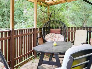 une terrasse en bois avec une table et des chaises. dans l'établissement Holiday home ULLARED III, à Ullared