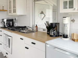 een keuken met witte kasten en een aanrecht bij Holiday home SÖLVESBORG XIII in Sölvesborg