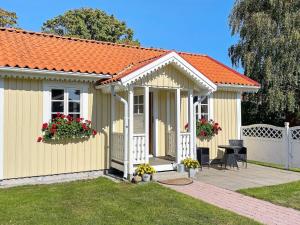 un petit bâtiment jaune avec un toit orange dans l'établissement Holiday home SÖLVESBORG XII, à Sölvesborg
