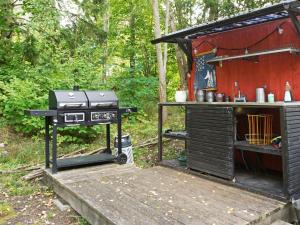a barbecue grill and a table in a forest at Holiday home BRO III in Bro