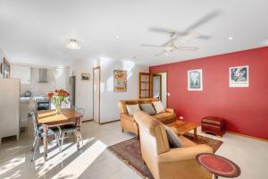 ein Wohnzimmer mit roten Wänden und einem Tisch in der Unterkunft Platypus Cottage Watch them play from the garden in Hobart