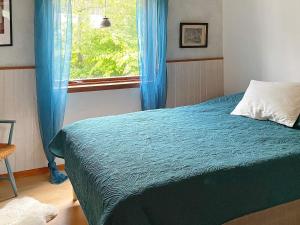 um quarto com uma cama e uma janela com cortinas azuis em Holiday home RONNEBY XI em Ronneby