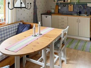 uma cozinha com uma mesa de madeira e 2 cadeiras em Holiday home RONNEBY XI em Ronneby