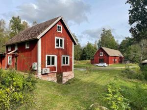a red barn and a white car in a field at 6 person holiday home in ASARUM-By Traum in Asarum +30 photos