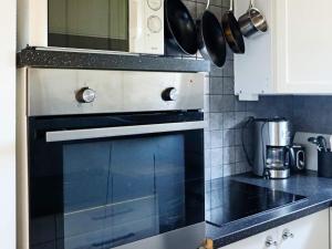 eine Küche mit Herd und Mikrowelle in der Unterkunft Holiday home LAHOLM in Laholm + 20 Fotos