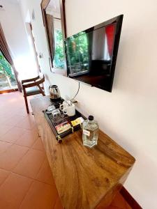 uma mesa de madeira numa sala de estar com televisão em Sabbay Kep em Kep
