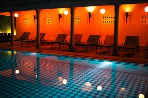 a swimming pool at night with chairs around it at Ranakpur Safari Resort in Sādri