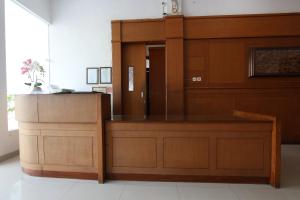 OYO 93188 Soren Hotel And Coffee في Lawean: قاعة محكمة مع مقعد وكشك خشبي