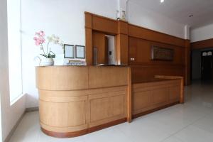 a wooden counter in a room with flowers on it at OYO 93188 Soren Hotel And Coffee in Lawean