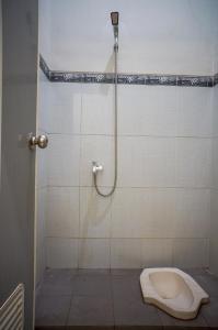 ein Bad mit einer Dusche und einem WC in der Unterkunft OYO 93186 HKP Homestay in Blitar