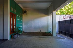 ein leerer Flur eines Gebäudes mit einer roten Tür in der Unterkunft OYO 93186 HKP Homestay in Blitar